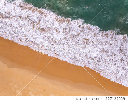 Top view beach with waves crashing on sandy shore,Beautiful waves sea surface in summer seascape background,Amazing beach colorful water background Top view beach with waves crashing on sandy shore,Beautiful waves sea surface in summer seascape background,Amazing beach colorful water background 127129639