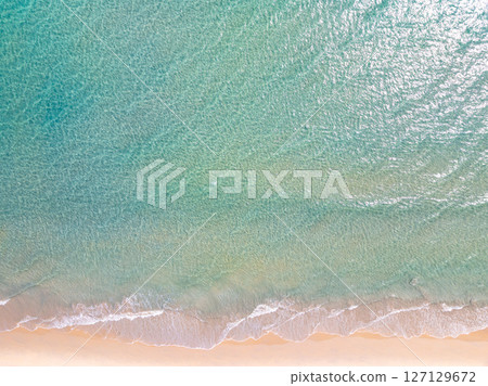 Top view beach with waves crashing on sandy shore,Beautiful waves sea surface in summer seascape background,Amazing beach colorful water background 127129672