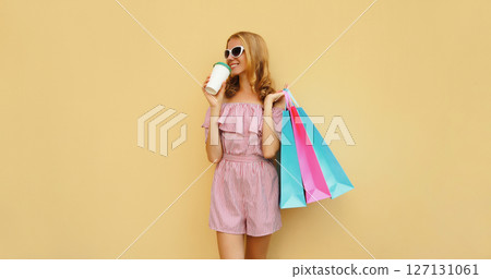 Stylish beautiful happy woman standing with colorful shopping bags posing in studio Stylish beautiful happy woman standing with colorful shopping bags posing in studio 127131061