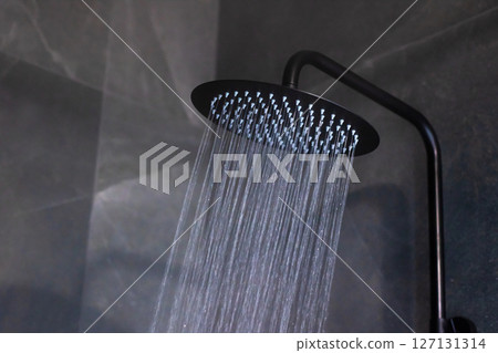 A sleek black shower head enhances your bathroom with cascading water A sleek black shower head enhances your bathroom with cascading water 127131314