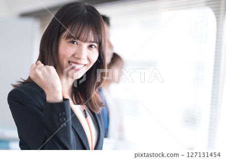 一位身穿西裝的年輕女子正在揮拳 127131454