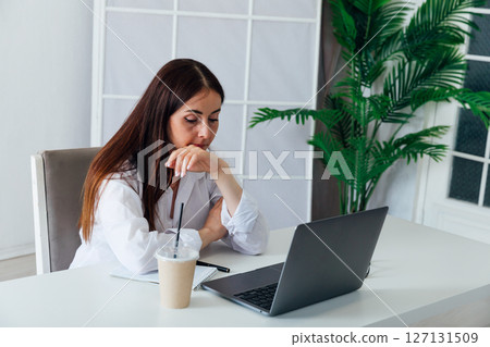 Business woman in glasses working on laptop at office desk online 127131509