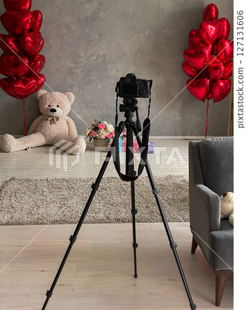 Camera on a tripod in a photo studio with balloons 127131606
