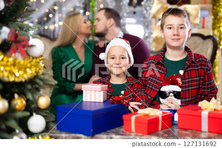 Smiling family celebrating Christmas and giving each other gifts 127131692