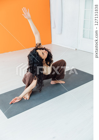 sports woman brunette doing gymnastics yoga asana in the gym sports woman brunette doing gymnastics yoga asana in the gym 127131838