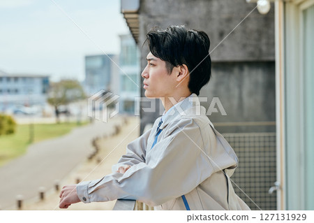 A young man thinking while looking outside A young man thinking while looking outside 127131929