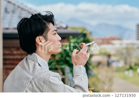 Young man smoking outside 127131930