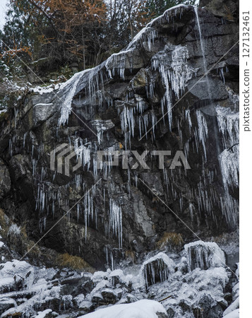 Frozen icicles dangling from rocky cliff edge in aosta, revealing winter's crystalline beauty against rugged mountainous terrain Lillaz 127132461