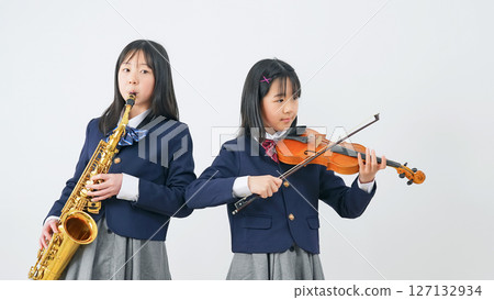 A group of female students practicing the saxophone and violin A group of female students practicing the saxophone and violin 127132934