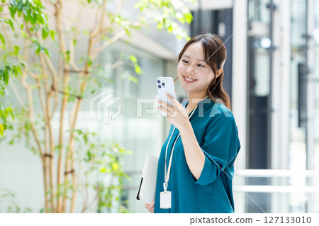 A young businesswoman using a smartphone in the office. Photo courtesy of Sky Perfect Tokyo Media Center 127133010