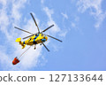 Helicopter operates above the clouds, transporting water in a bold firefighting mission 127133644