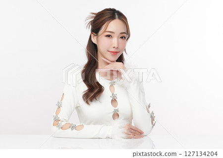A beautiful young Asian woman with clean, fresh skin against a white background. Skincare, facial treatment, cosmetology, beauty, and spa. An elegant portrait of an Asian woman. 127134204