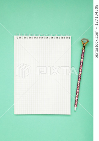 A notebook with a blank page and pen on mint background. Copy space, layout, mockup. A notebook with a blank page and pen on mint background. Copy space, layout, mockup. 127134308