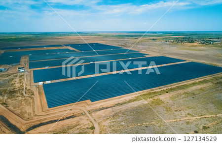 Solar energy farm located in a vast arid landscape generating renewable energy under clear blue skies 127134529