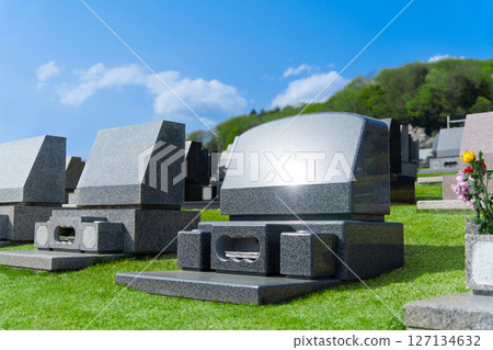 Western-style gravestones in a lawn cemetery. A landscape image of a cemetery on a sunny day. 127134632