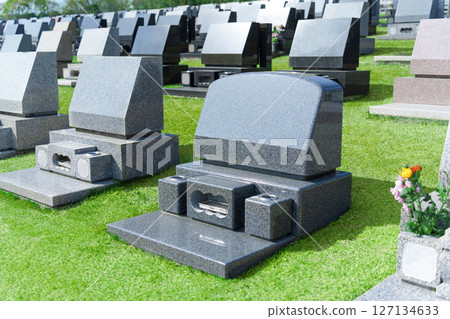 Western-style gravestones in a lawn cemetery. A landscape image of a cemetery on a sunny day. 127134633