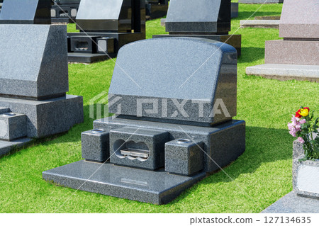 Western-style gravestones in a lawn cemetery. A landscape image of a cemetery on a sunny day. 127134635