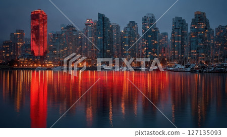 This dusk panorama captures a vibrant cityscape with reflections in the water, highlighting illuminated architecture and the city's dynamic skyline 127135093