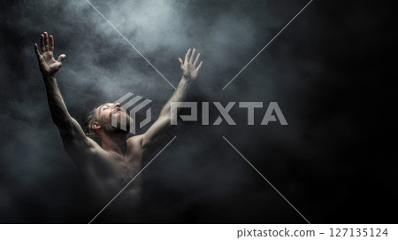 A muscular man with a beard raises his arms to the heavens, enveloped in a smoky, ethereal atmosphere 127135124