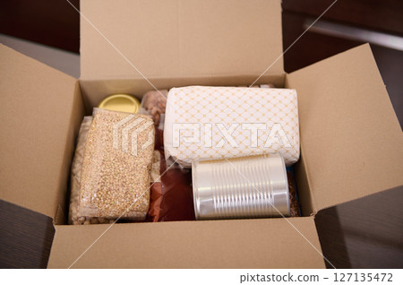 Cardboard Box Containing Various Food Items Such as Grains, Beans, and Canned Goods Cardboard Box Containing Various Food Items Such as Grains, Beans, and Canned Goods 127135472