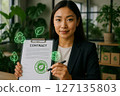Professional woman holding sustainable contract with green certification icons symbolizing eco friendly procurement and supply chain practices 127135803