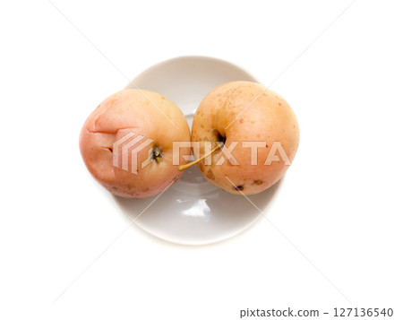 Pickled apples in a plate on a white background. Pickled apples in a plate on a white background. 127136540