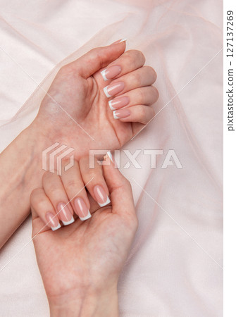 Woman showing french manicure on pink background Woman showing french manicure on pink background 127137269