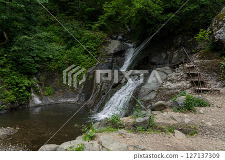 An observation deck near a small waterfall in the mountains of Georgia An observation deck near a small waterfall in the mountains of Georgia 127137309