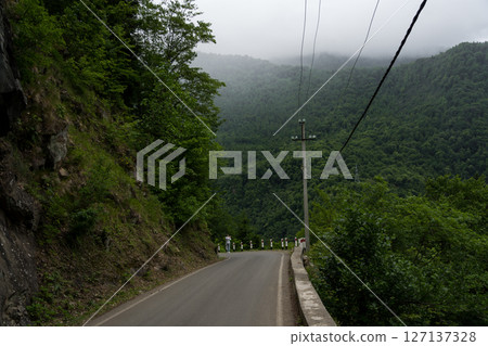 The road leading down. Incredible view of the mountains, clouds in the mountains 127137328
