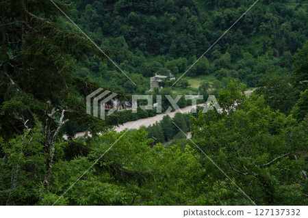 A river flowing at the foot of mountains in Georgia, cloudy sky 127137332
