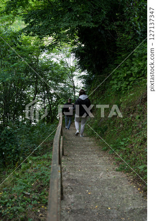 A girl walks down the steps in a forest in the mountains A girl walks down the steps in a forest in the mountains 127137347