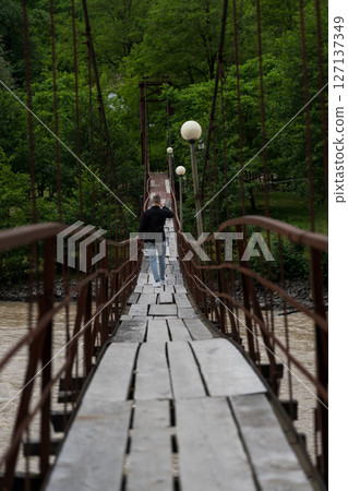 Wooden suspension bridge over the Cheryokha River, Georgia 127137349