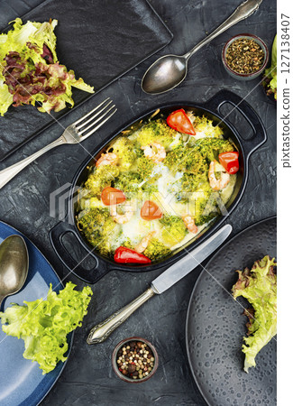 Oven baked broccoli topped with melted mozzarella and prawns. 127138407