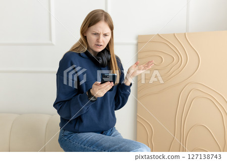 Shocked concerned cellphone user girl staring at screen, looking at smartphone screen, finding problems with online app, poor connection, Internet service, getting surprising bad news Shocked concerned cellphone user girl staring at screen, looking at smartphone screen, finding problems with online app, poor connection, Internet service, getting surprising bad news 127138743