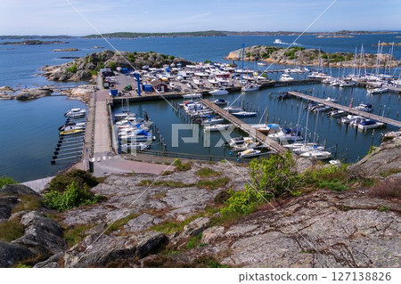 Archipelago ferry leaving harbour with ships at Saltholmen peninsula on the shore of Alvsborgsfjorden, Alvsborg district, Gothenburg, Sweden, sunny day 127138826