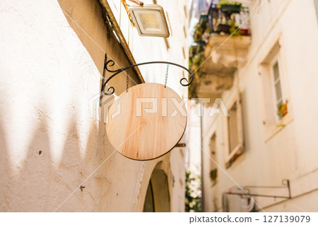 Blank signboard on stone building wall in Mediterranean alley. Concept of urban signage, empty brand space, and local European architecture. Copy space Blank signboard on stone building wall in Mediterranean alley. Concept of urban signage, empty brand space, and local European architecture. Copy space 127139079