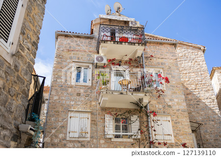 Old Mediterranean stone house with balconies. Urban charm, historical architecture, vertical living, and floral aesthetics. Old Mediterranean stone house with balconies. Urban charm, historical architecture, vertical living, and floral aesthetics. 127139110