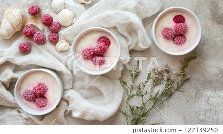 Beach picnic with berry tiramisu in cups, seashells and linen napkins, coastal summer mood 127139250