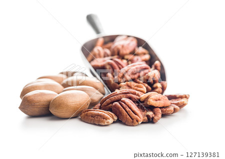 Peeled pecan nuts in scoop isolated on white background. Peeled pecan nuts in scoop isolated on white background. 127139381