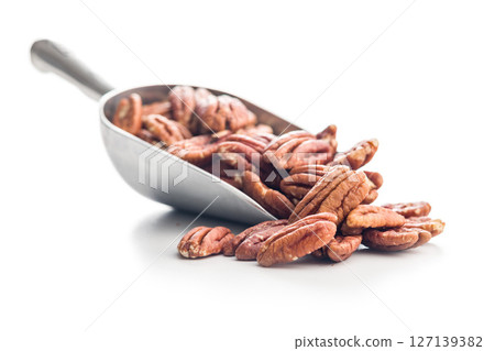 Peeled pecan nuts  in scoop isolated on white background. 127139382