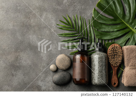 Natural skincare products with green leaves and massage brush 127140132
