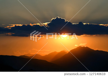 A breathtaking sunset where the sun is partially obscured by a dense cloud.  127140610
