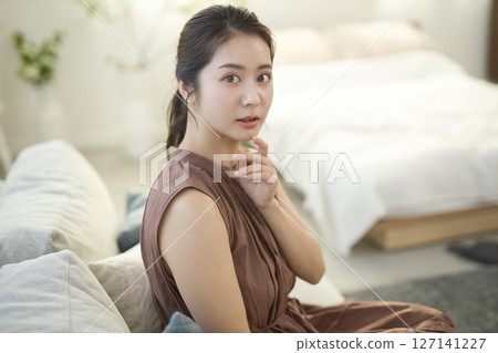 Woman in her 20s sitting on the sofa Beauty image 127141227