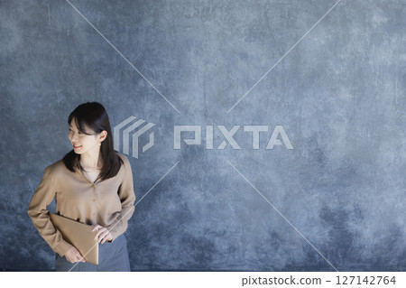 Woman standing with a laptop 127142764