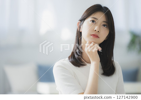 Young woman thinking in the room 127142900