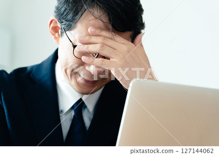 A businessman who is not good at using a computer 127144062