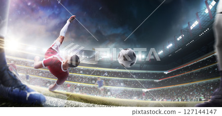 A footballer performs a powerful overhead kick while falling. Soccer action game. Rear view. Soccer players playing with ball at stadium A footballer performs a powerful overhead kick while falling. Soccer action game. Rear view. Soccer players playing with ball at stadium 127144147