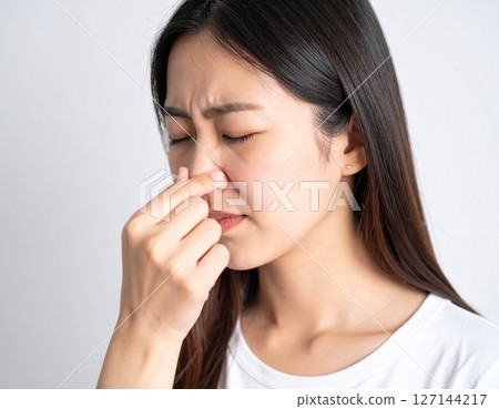 年輕女子捏住鼻子以抵禦難聞的氣味 127144217