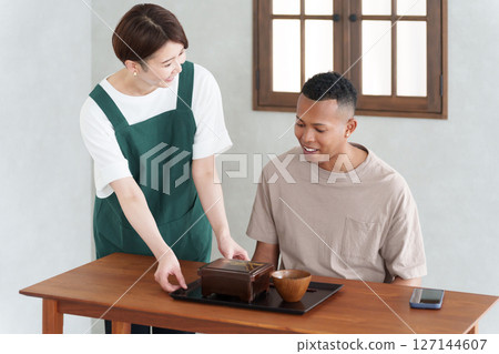 Foreign tourists eating Japanese food and restaurant staff Foreign tourists eating Japanese food and restaurant staff 127144607