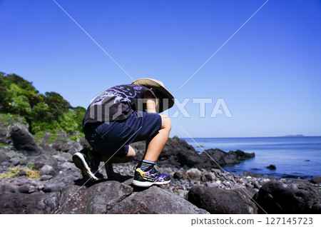 <素材> 小學生來到海灘在岩石上玩耍 127145723